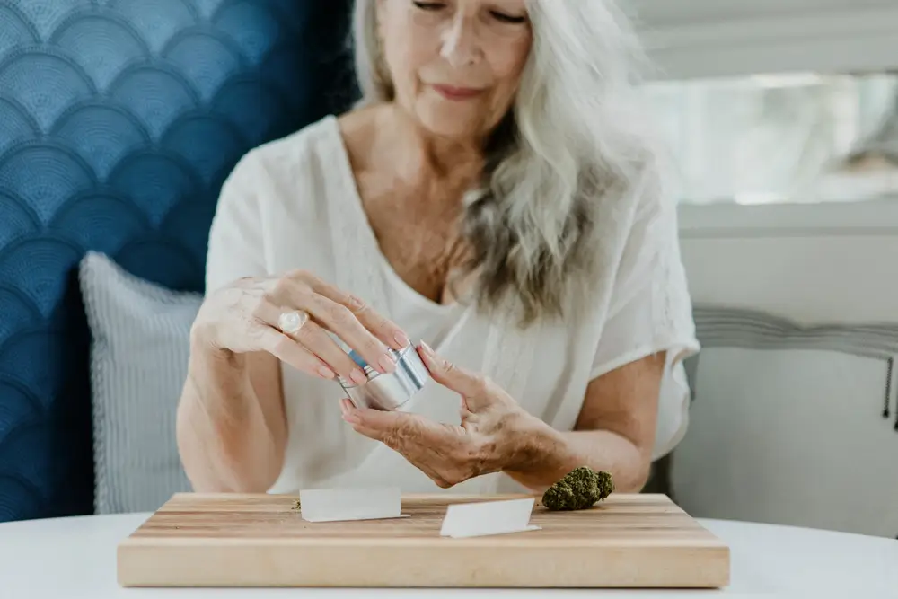 A woman applying lotion on her hands at home.